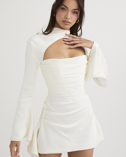 Three-quarter view of the white satin mini dress with halter cut out and bell sleeves, showcasing the dress structure.