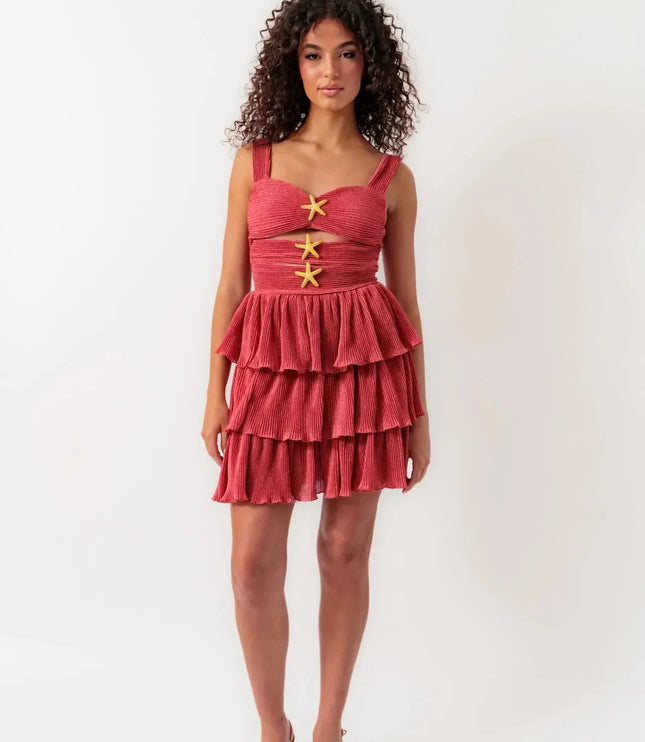 Full view of women's coral summer cut out mini dress with tiered ruffles and starfish details, paired with neutral heels.