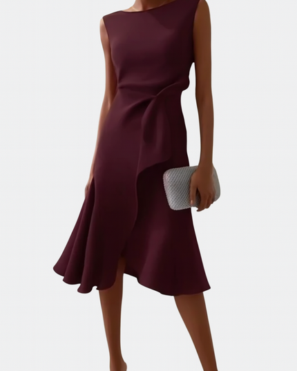 Front view of a women's sleeveless burgundy midi dress, featuring an elegant draped asymmetric hemline and a silver clutch.