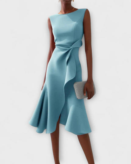 Light blue sleeveless midi dress with a sophisticated draped asymmetric cut, featuring a ruffled accent at the waist and a flowing skirt.