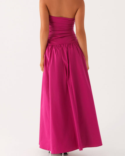 Back view of a women's fuchsia strapless ruched maxi dress, highlighting the drop waist and full skirt.