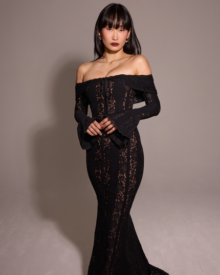 Women's black off-shoulder floral lace maxi dress, with the model looking forward, highlighting the dress's design.