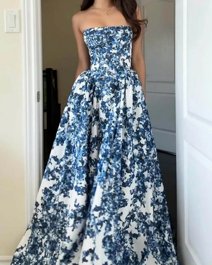 Front view of a women's strapless formal maxi dress in blue and white floral print, highlighting the dress's flowing fabric.