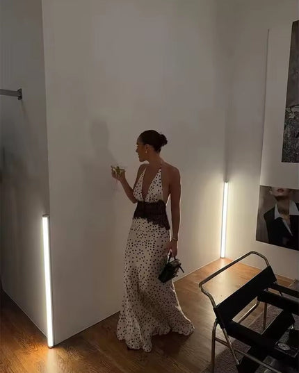 Women's polka dot halter neck lace maxi dress in a room setting, showing the full length of the dress with black lace detail.