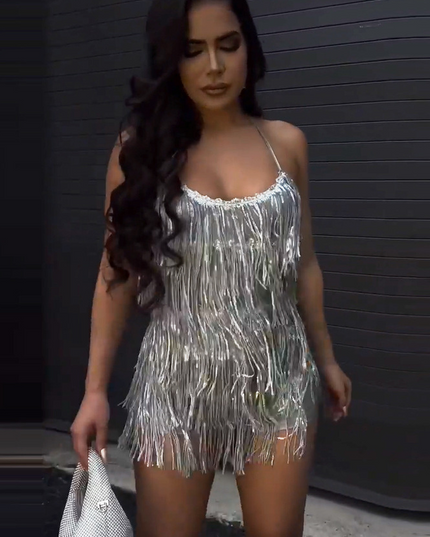 Front view of the women's silver fringe halter neck mini two-piece set, with a silver embellished handbag.