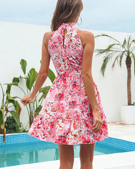 Back view of a pink floral halter neck tiered mini dress with a keyhole opening.