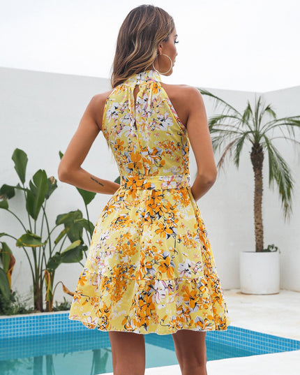 Back view of the women's yellow floral halter neck mini dress, featuring a keyhole detail and tied belt.