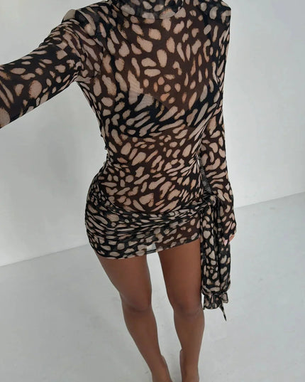 Overhead view of women's leopard print high neck ruched mini dress, showcasing sheer fabric and print.