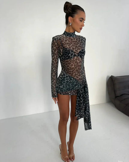 Side profile of women's dark leopard print high neck ruched mini dress with sheer long sleeves and clear heels.