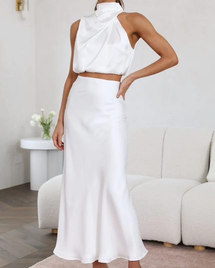 Full length view of women's white satin asymmetrical high neck crop top and elegant maxi skirt set, a chic wedding suit.