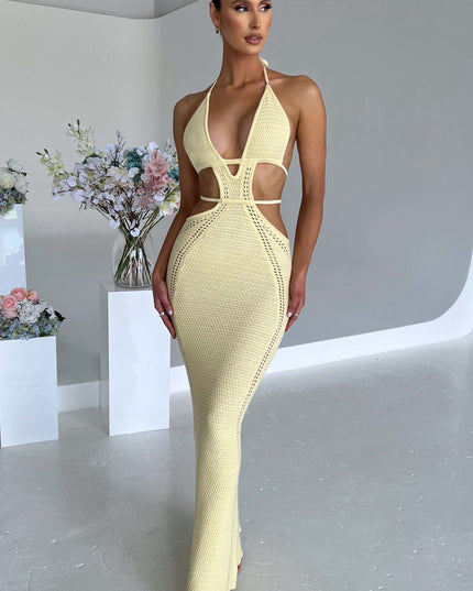 Standing shot of a woman in a light yellow crochet knit plunge halter cut-out maxi dress, for a summer event.