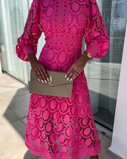 Close-up of a bright pink long sleeve lace midi dress, showing high neck and detailed lace patterns
