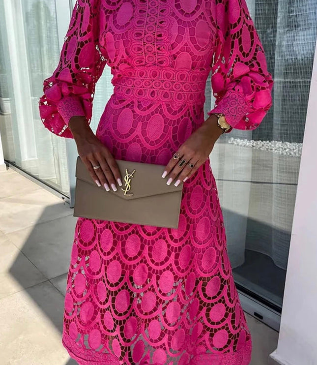 Close-up of a bright pink long sleeve lace midi dress, showing high neck and detailed lace patterns