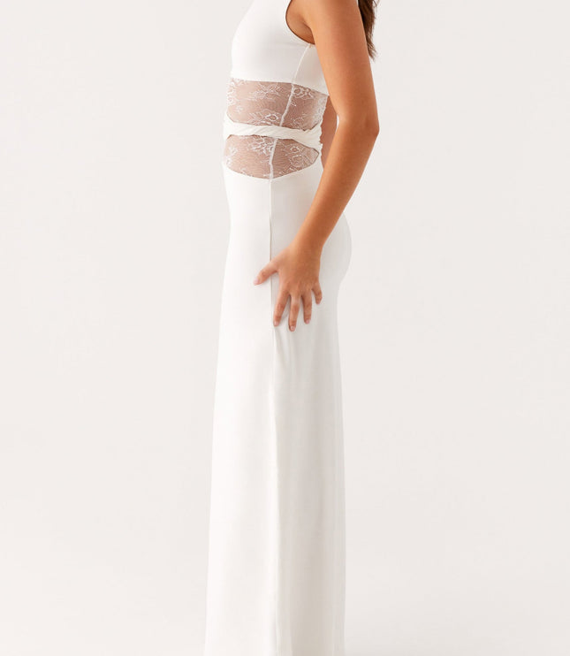 Side profile of a women's white sleeveless maxi dress, showcasing the crew neck and intricate lace panel design.