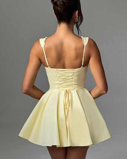 Back view of a women's lemon yellow pintuck mini dress featuring a detailed lace-up corset style back.