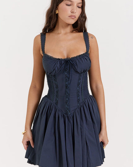 Close-up front view of navy blue corset mini dress with lace-up detail, shirred bodice, and delicate lace trim.