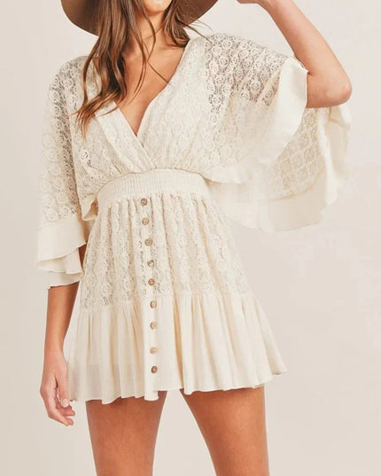 Front view of a cream lace V-neck mini romper featuring a smocked waist and delicate button details.