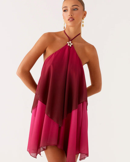 Front view of a women's halter neck layered chiffon mini dress in a rich burgundy and fuchsia ombre, with hands on hips.