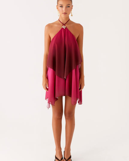 Full length front view of a women's layered chiffon mini dress, featuring a deep burgundy to fuchsia ombre and a shell detail.
