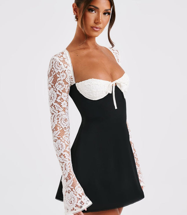 Women's black mini dress with white lace long sleeves and bustier top, featuring a sweetheart neckline and tie detail.