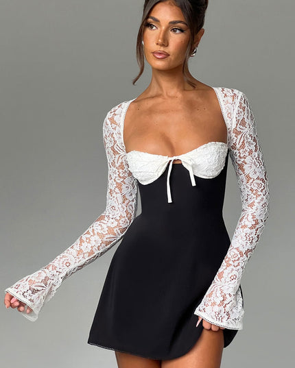 Women's black and white lace mini dress with long bell sleeves, captured in a dynamic pose.
