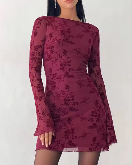 Front view of a maroon floral print long sleeve mini dress, featuring a boat neck and sheer bell sleeves with a lettuce hem.