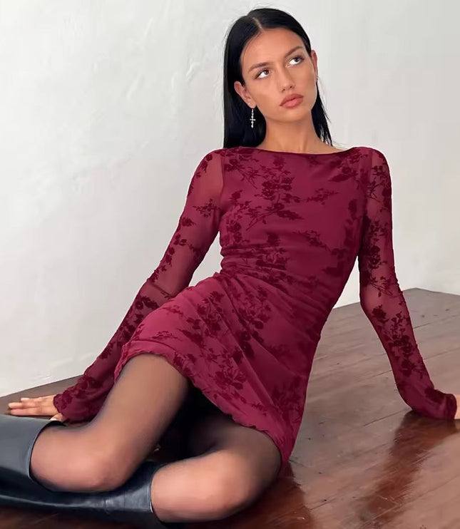 Maroon floral print long sleeve mini dress with boat neck, sheer sleeves, and lettuce hem, a woman sitting on a wooden floor.