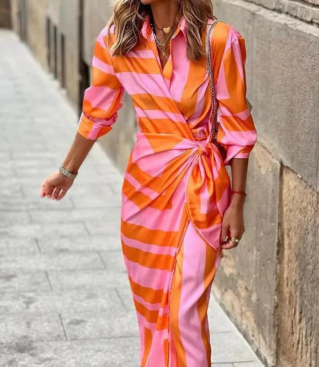 Women's long sleeve V-neck midi dress in a vibrant orange and pink striped print, shown with a knotted waist.