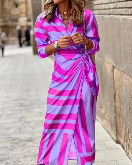 Women's long sleeve V-neck midi dress in a bold pink and purple striped pattern, featuring a front knot detail.