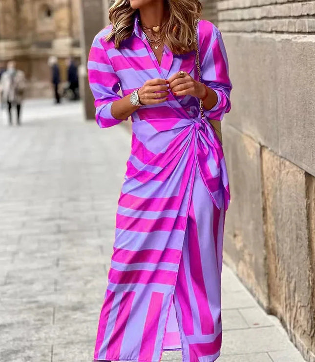 Women's long sleeve V-neck midi dress in a bold pink and purple striped pattern, featuring a front knot detail.