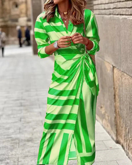 Women's long sleeve V-neck midi dress with a vibrant green and light green striped pattern, tied at the waist.