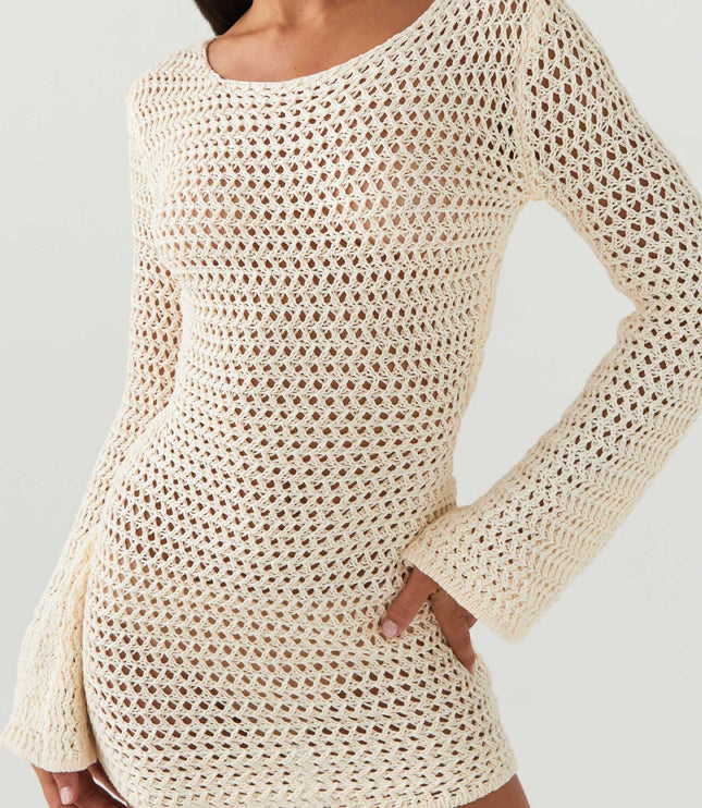 Detail shot of the cream long sleeve crochet mini dress, highlighting the open knit and texture of the fabric.