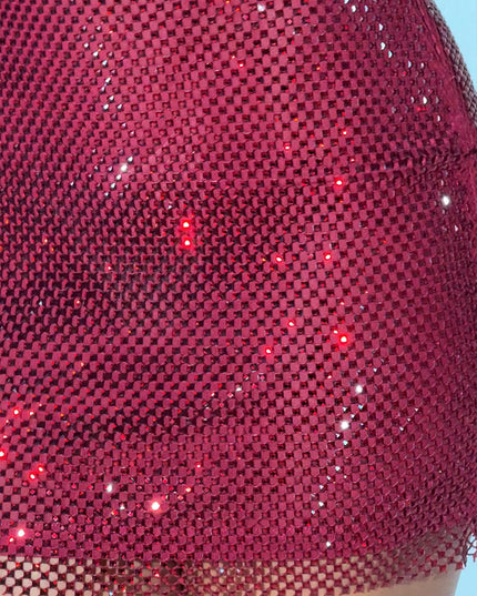 Close-up detail of the red rhinestone fabric on the women's mini dress, showing the intricate mesh and individual sparkling stones.