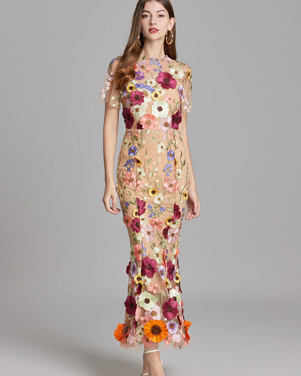 Women's multi-color floral embroidered sheer maxi prom dress, short sleeves, in a confident pose.