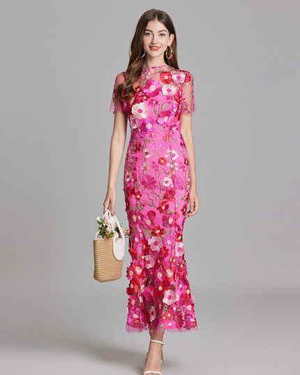 Full-length view of a women's vibrant pink floral embroidered sheer maxi prom dress with short sleeves and a basket.