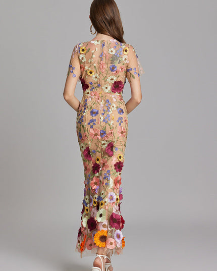 Back view of women's multi-color floral embroidered sheer maxi prom dress, short sleeves, showing floral pattern.