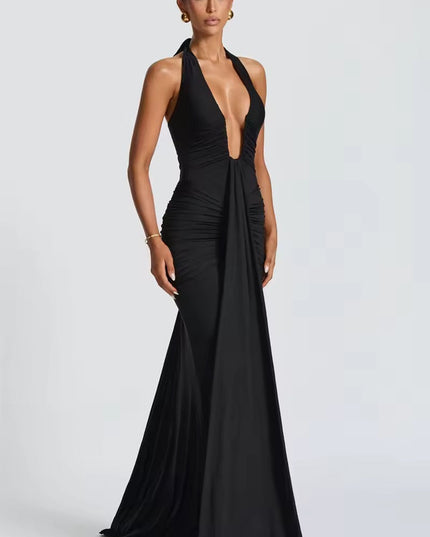 Side profile of a black deep V halter ruched mermaid maxi dress, highlighting the flowing skirt and ruching.