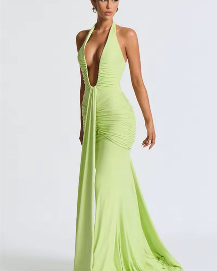 Side view of a light green deep V halter ruched mermaid maxi dress, displaying the flowing mermaid skirt and ruched bodice.