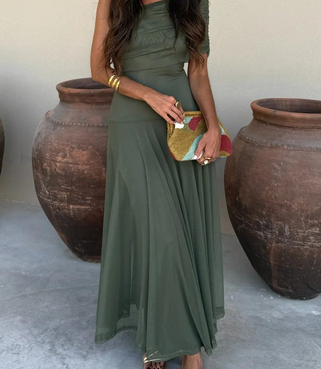 Women's olive green drape one shoulder mesh maxi dress, styled with gold sandals and a colorful clutch.