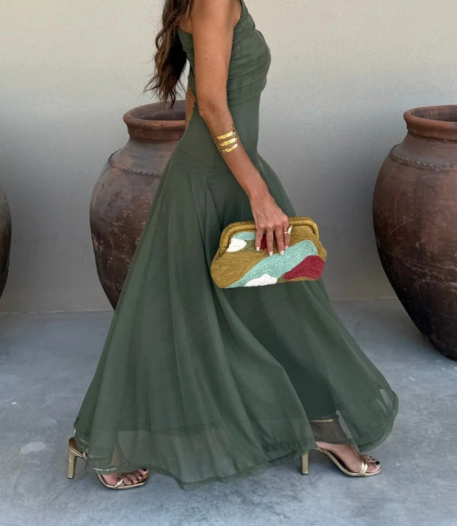 Side view of olive green one-shoulder mesh maxi dress, showcasing the full skirt and gold high heels.