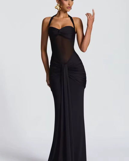 Full view of a women's black halter neck ruched mesh maxi dress, with sheer midriff and elegant draping.