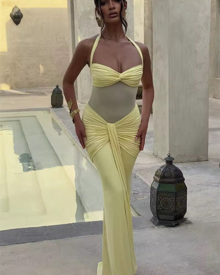 Full-length view of a women's prom halter neck ruched mesh maxi dress in a soft pastel yellow, with a sheer midsection and elegant ruching.