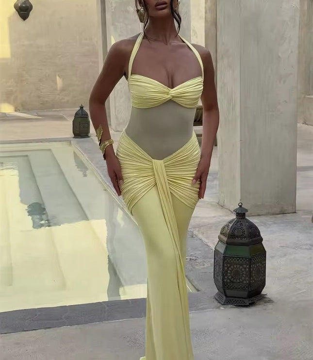 Full-length view of a women's prom halter neck ruched mesh maxi dress in a soft pastel yellow, with a sheer midsection and elegant ruching.