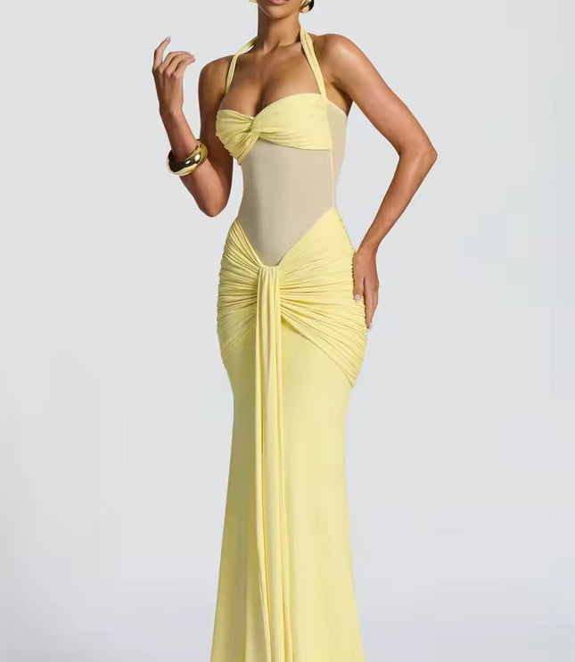 Side view of a women's light yellow prom dress, showcasing the halter neck, ruched mesh details, and the elegant drape of the maxi skirt.