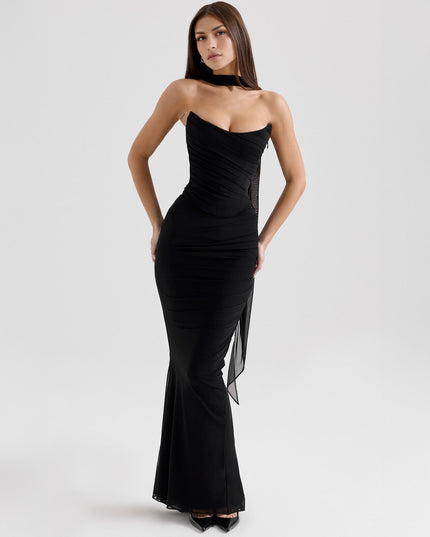 Elegant black strapless mesh ruched maxi dress with flowing sheer fabric detail, styled for a formal event.