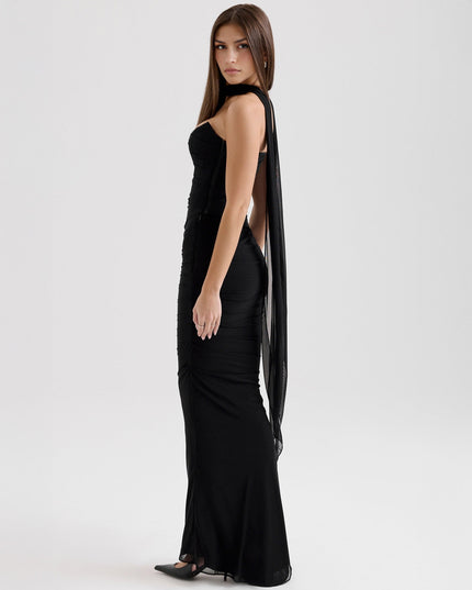 Side profile of a black strapless mesh ruched maxi dress, showcasing the floor-length skirt and sheer fabric.