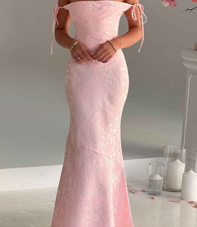 Women's off-shoulder pink floral maxi dress, showcasing the tie-strap detail and elegant, flowing design.