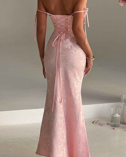 Rear view of women's pink floral off-shoulder maxi dress, highlighting the lace-up back and elegant drape.