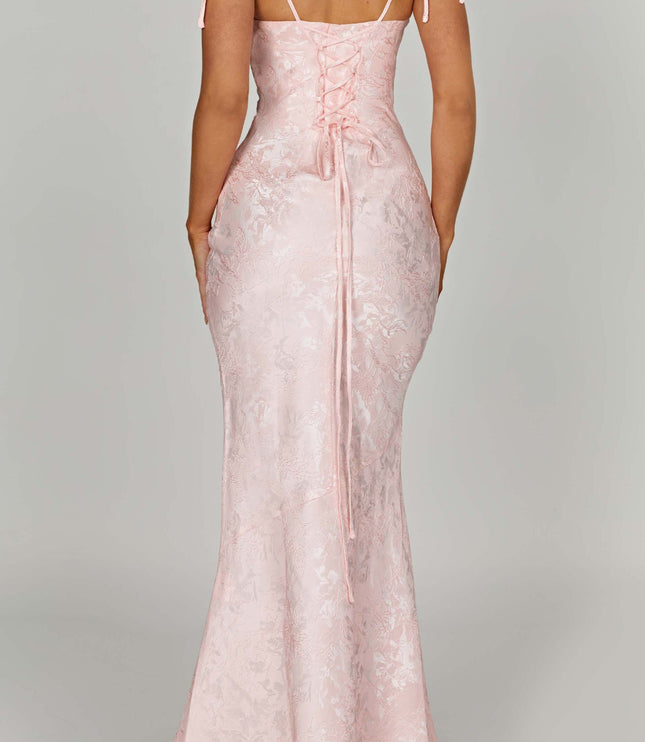 Back view of the pink floral maxi dress on a plain background, emphasizing the lace-up back and long skirt.