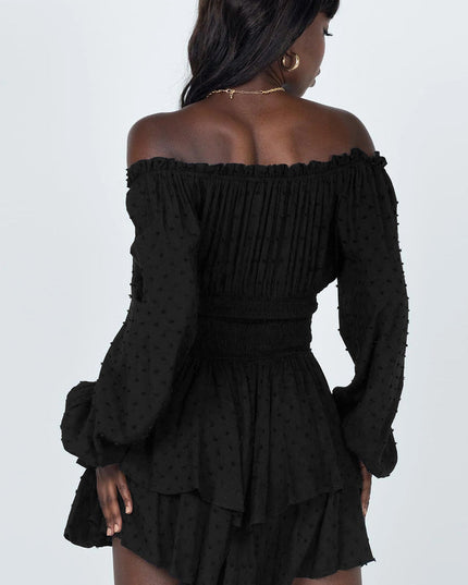 Back view of black off-shoulder mini dress, showing shirred waist and tiered skirt